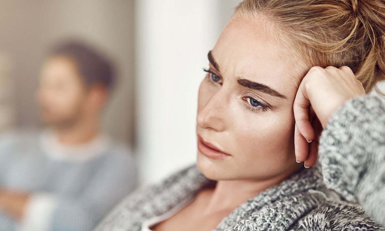 Frau und Mann sitzen auf dem Sofa und haben Streit