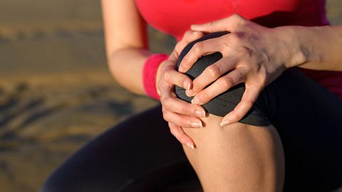 Eine Frau hat einen Krampf im Bein - Foto: Shutterstock