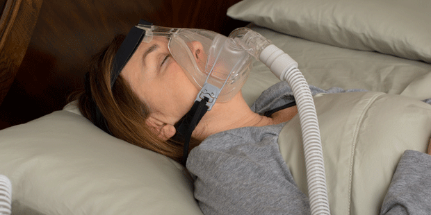 Eine Frau schläft mit Atemmaske