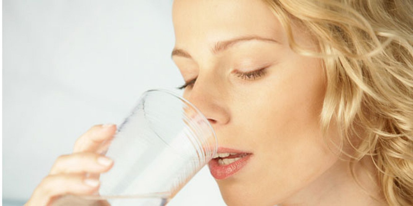 Frau trinkt ein Glas Wasser