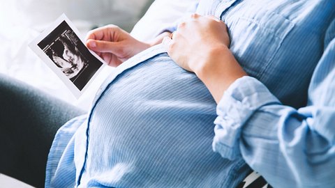 Schwangere Frau hält Ultraschallbild in der Hand - Foto: istock/Nataliaderiabina