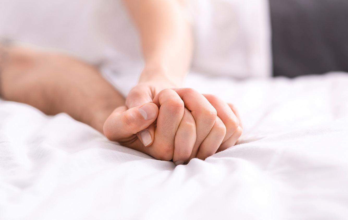Eine Männerhand greift beim Sex in eine Frauenhand