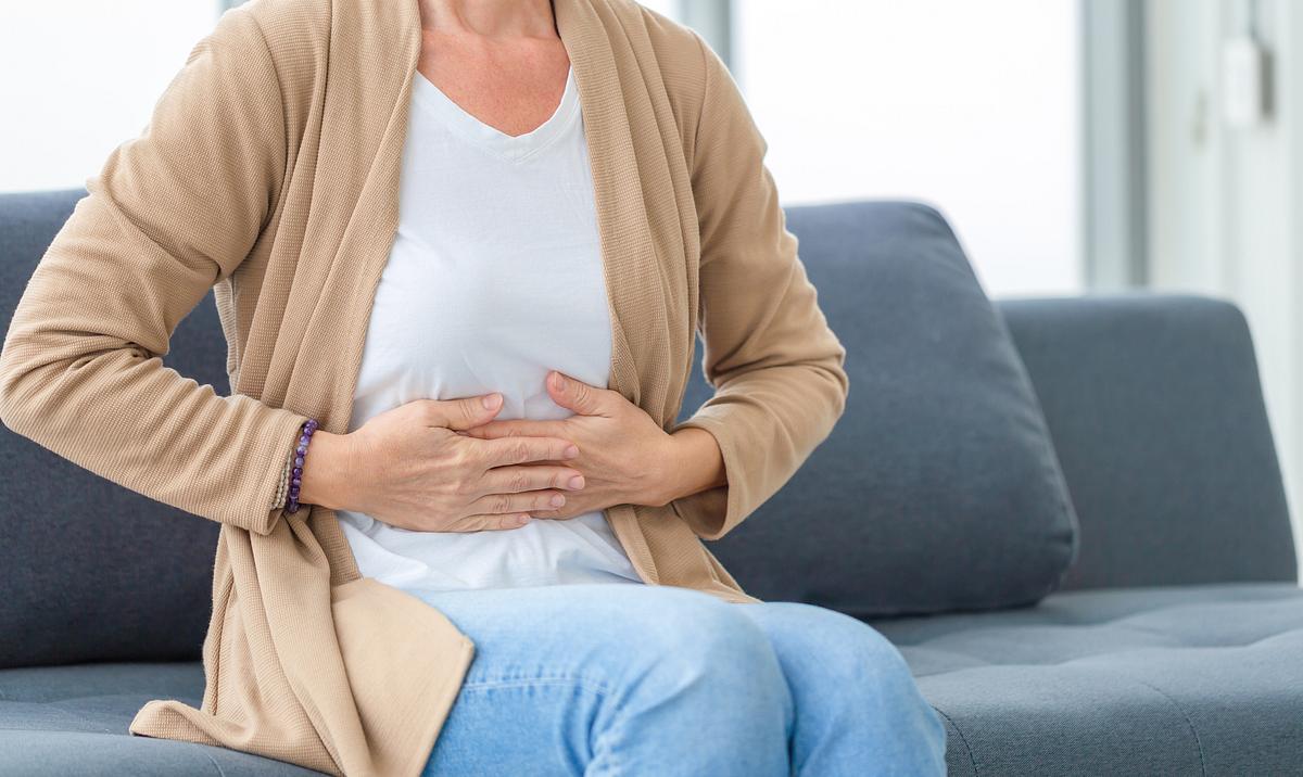 gallensteine-selbsttest Eine Frau hält ihre Hände vor ihrem schmerzenden Bauch