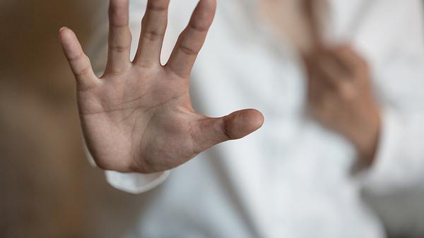 Frau hält die Hand vor ihren Körper - Foto: istock/tinnakorn_jorruang