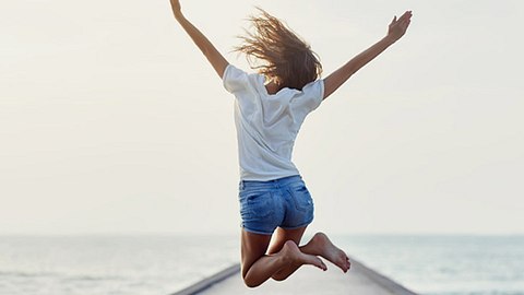 Eine Frau springt aus lauter Glücksgefühlen in die Höhe - Foto: iStock