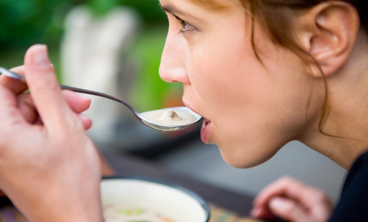 Eine Frau isst Suppe
