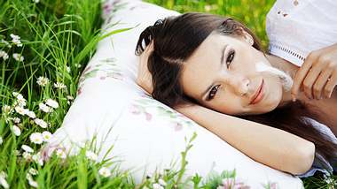 Frau liegt auf Blumenwiese - Foto: shutterstock