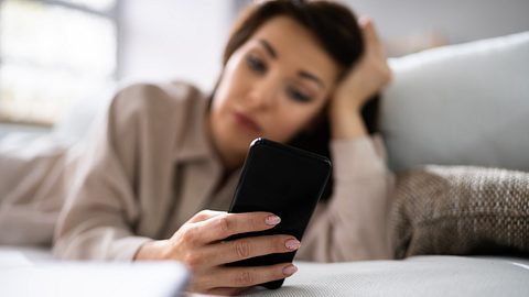 Eine Frau schaut sorgenvoll auf ihr Handy - Foto: iStock_tommaso79