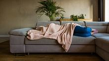 Frau liegt auf dem Sofa flach - Foto: iStock/izusek