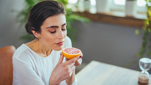 Eine Frau isst eine Grapefruit - Foto: iStock/dragana991 