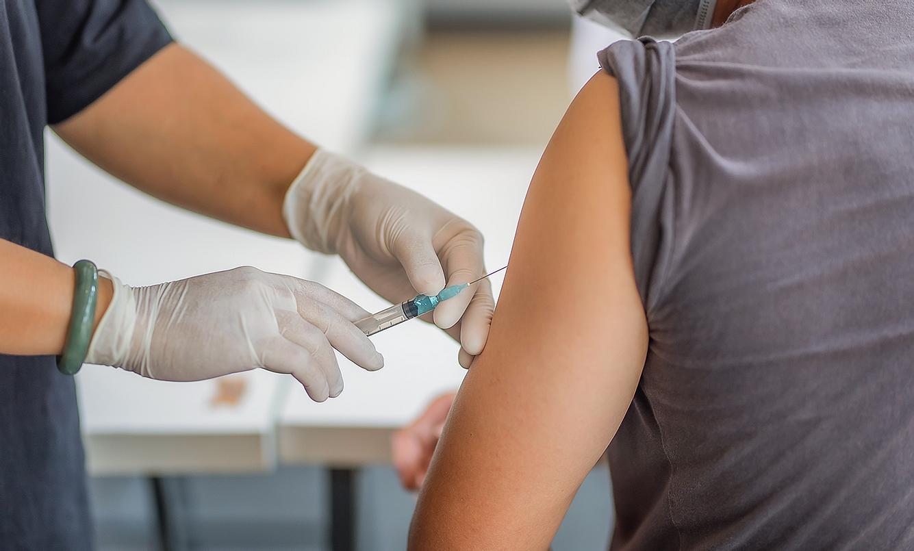 Person bekommt Impfstoff in den Arm