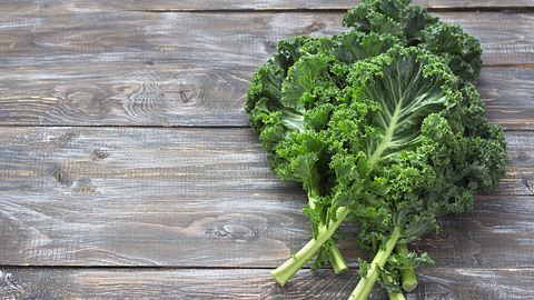 Grünkohl liegt auf Holzbrett - Foto: iStock/OlgaLepeshkina