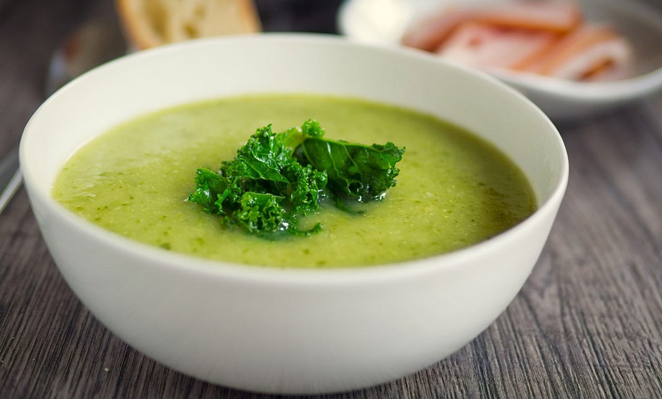 Grüne Suppe in Schale auf dem Tisch