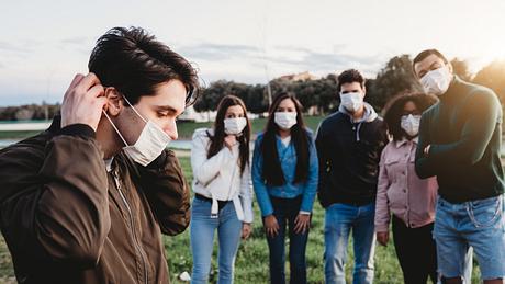 Gruppe junger Menschen mit Mundschutz - Foto: iStock_FilippoBacci