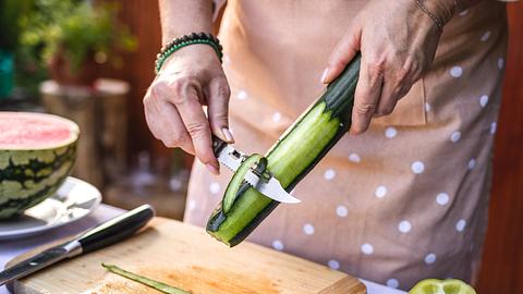 Frau schält eine Gurke - Foto: iStock/Zbynek Pospisil