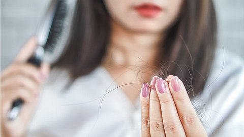 Frau fallen die Haare aus - Foto: iStock/Doucefleur