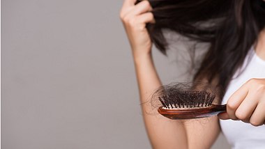 Eine Frau hält eine Bürste mit einem Büschel voll Haaren in der Hand - Foto: istock_spukkato