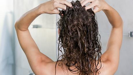 Frau steht unter der Dusche und wäscht sich die Haare - Foto: iStock/triocean
