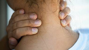 Eine Frau massiert ihren Nacken - Foto: iStock / simarik