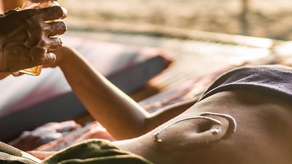 Frau lässt sich Bauch mit Öl massieren - Foto: iStock/skynesher