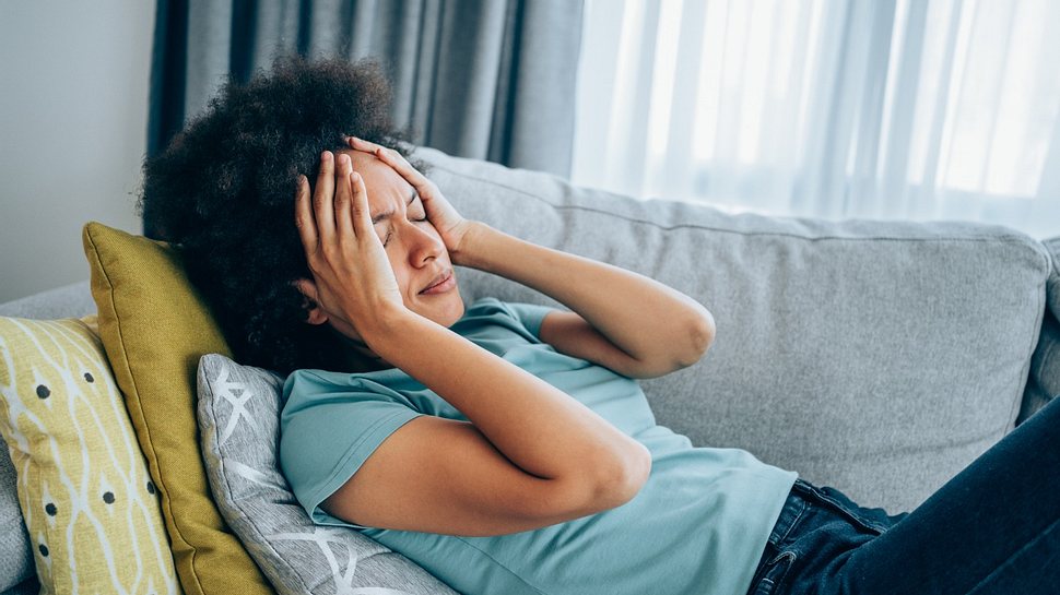 Eine Frau mit Schwindel liegt auf dem Sofa - Foto: iStock_VioletaStoimenova
