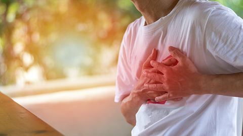 Mann hält seine Hände an die Brust - Foto: iStock/Pornpak Khunatorn