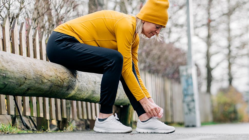 Eine Frau bindet sich ihren Schuh zu - Foto: iStock/HRAUN