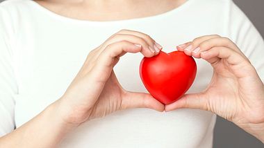 Frau hält rotes Herz in Händen - Foto: iStock /simarik