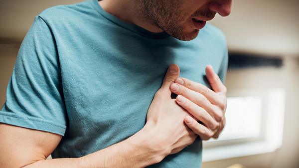 Ein Mann hält seine Hände an seiner schmerzenden Brust - Foto: iStock_RgStudio