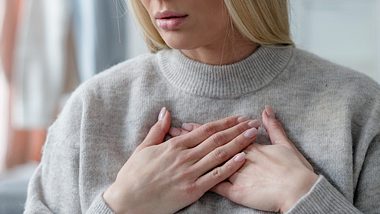 Frau mit Hinterwandinfarkt-Symptomen fasst sich an den Brustkorb - Foto: iStock/brizmaker