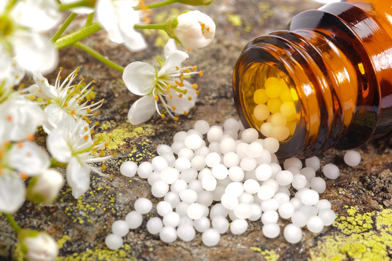 homoeopathie-bei-erkaeltungen umgekippte Globuliflasche und Blüten