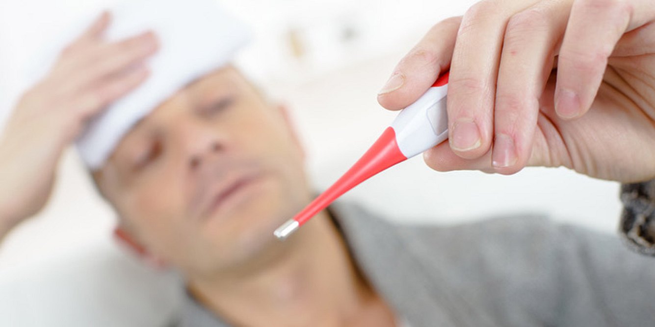 Mann mit Fieberthermometer