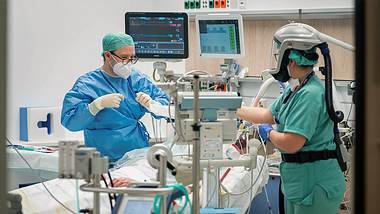 Personal auf Intensivstation versorgt einen Patienten - Foto: IMAGO / Max Stein