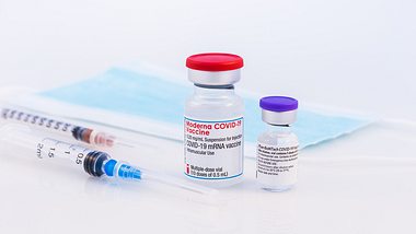 Ampullen mit Impfstoff, daneben zwei Spritzen und eine medizinische Maske - Foto: istock/carmengabriela