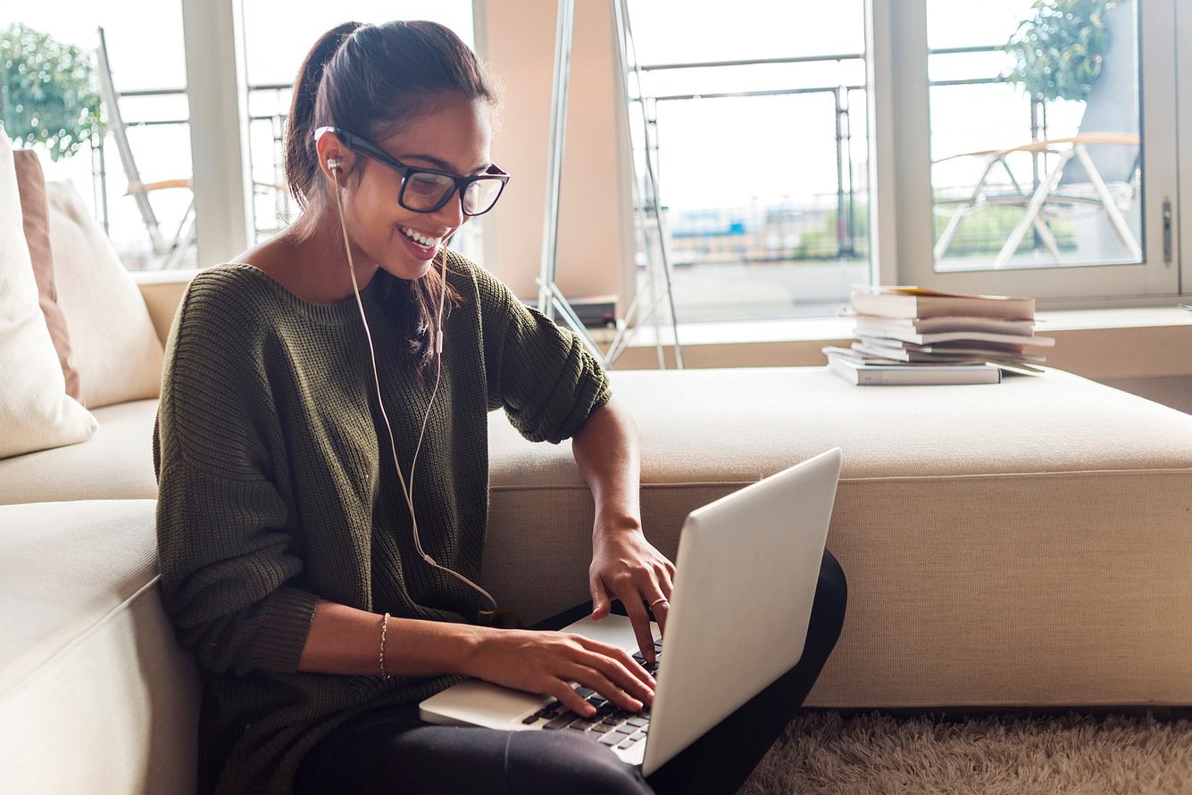 Eine Frau mit Brille arbeitet am Laptop und lacht Eine Frau mit Brille arbeitet am Laptop und lacht