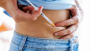 Eine Frau setzt sich eine Spritze in den Bauch - Foto: iStock/nensuria