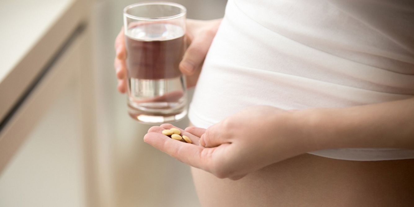Schwangere Frau nimmt Tabletten