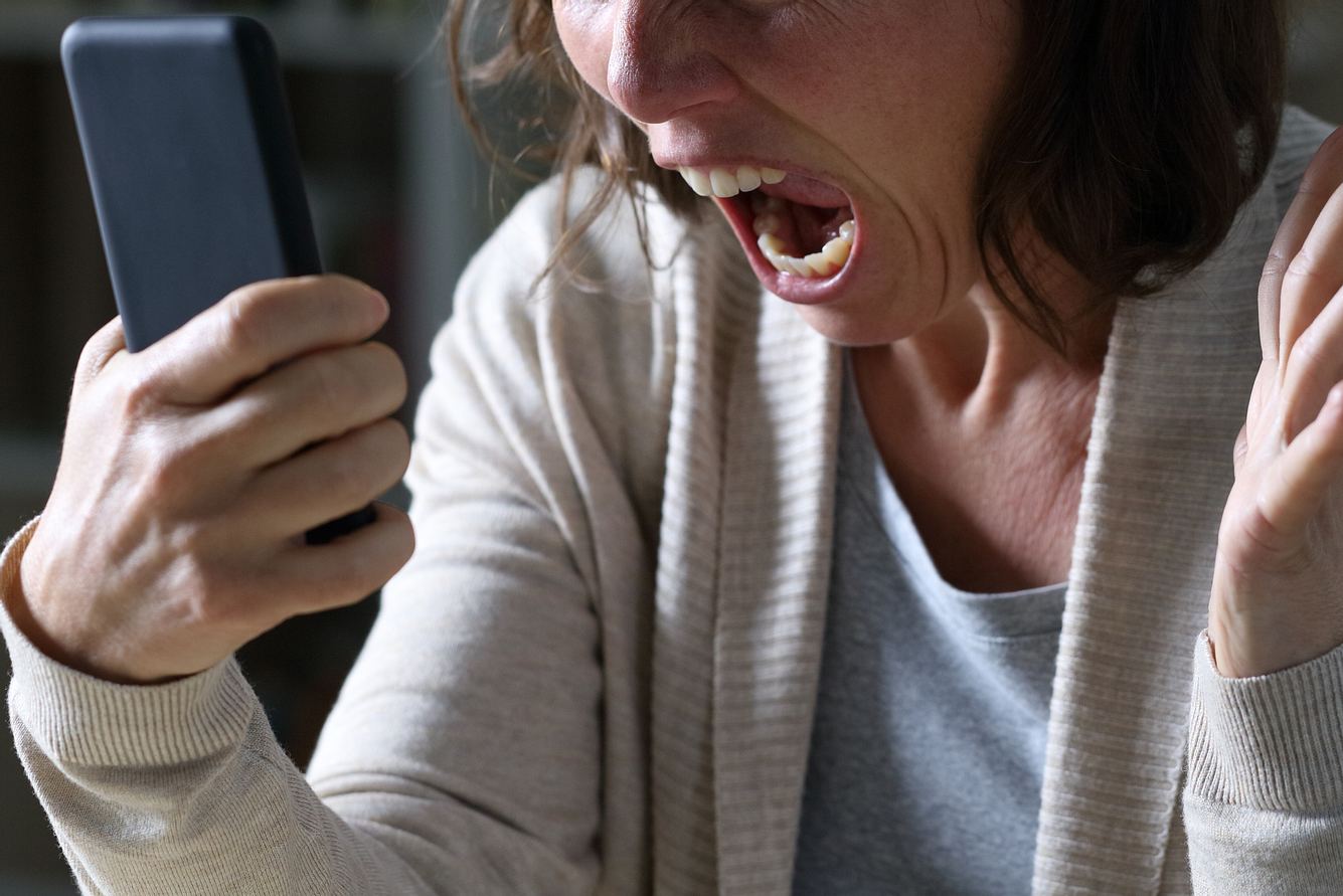 Eine Frau schreit in ihr Smartphone