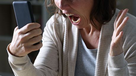 Eine Frau schreit in ihr Smartphone - Foto: iStock/Pheelings Media