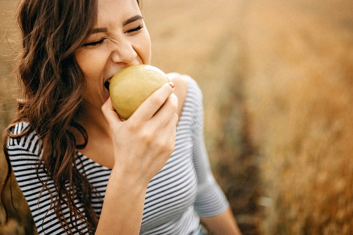 Frau beißt in einen Apfel
