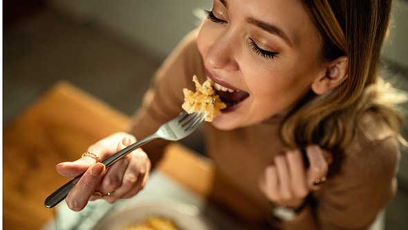 Eine Frau isst Nudeln - Foto: iStock/Drazen Zigic