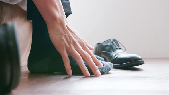 Ein Mann kratzt seine Füße - Foto: iStock_RyanKing999