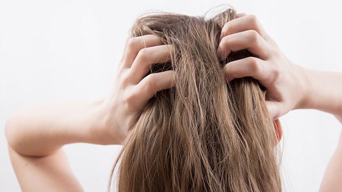 Frau fasst sich an den Hinterkopf - Foto: istock/foto_ruletka