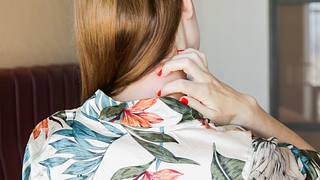 Eine Frau kratzt sich im Nacken - Foto: iStock/triocean