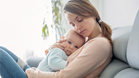Mutter hält krankes Baby im Arm. - Foto: iStock/tatyana_tomsickova