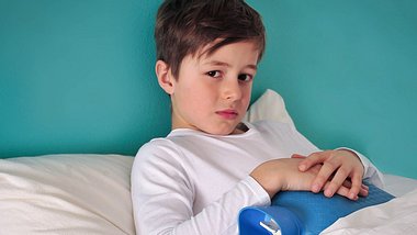 Junge liegt mit Schmerzen im Bett - Foto: Fotolia