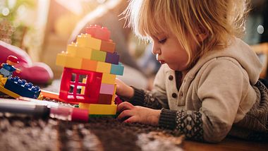 Kind spielt mit Legosteinen - Foto: iStock/skynesher
