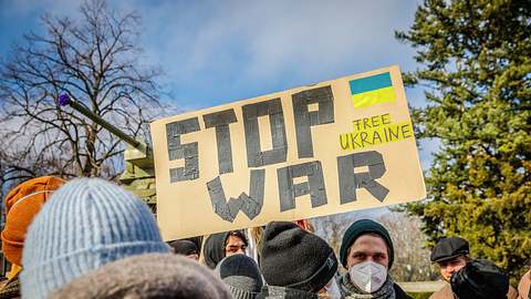 Demonstranten mit einem Anti-Kriegsplakat - Foto: IMAGO/David Weyand