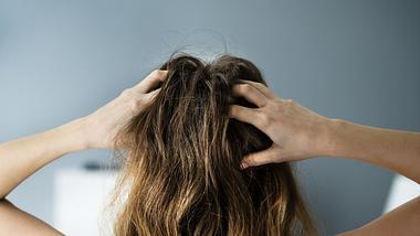 Frau hält ihren schmerzenden Kopf - Foto: iStock_AndreyPopov