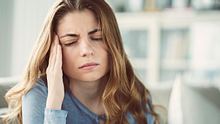 Frau mit Kopfschmerzen drinnen - Foto: iStock/seb_ra